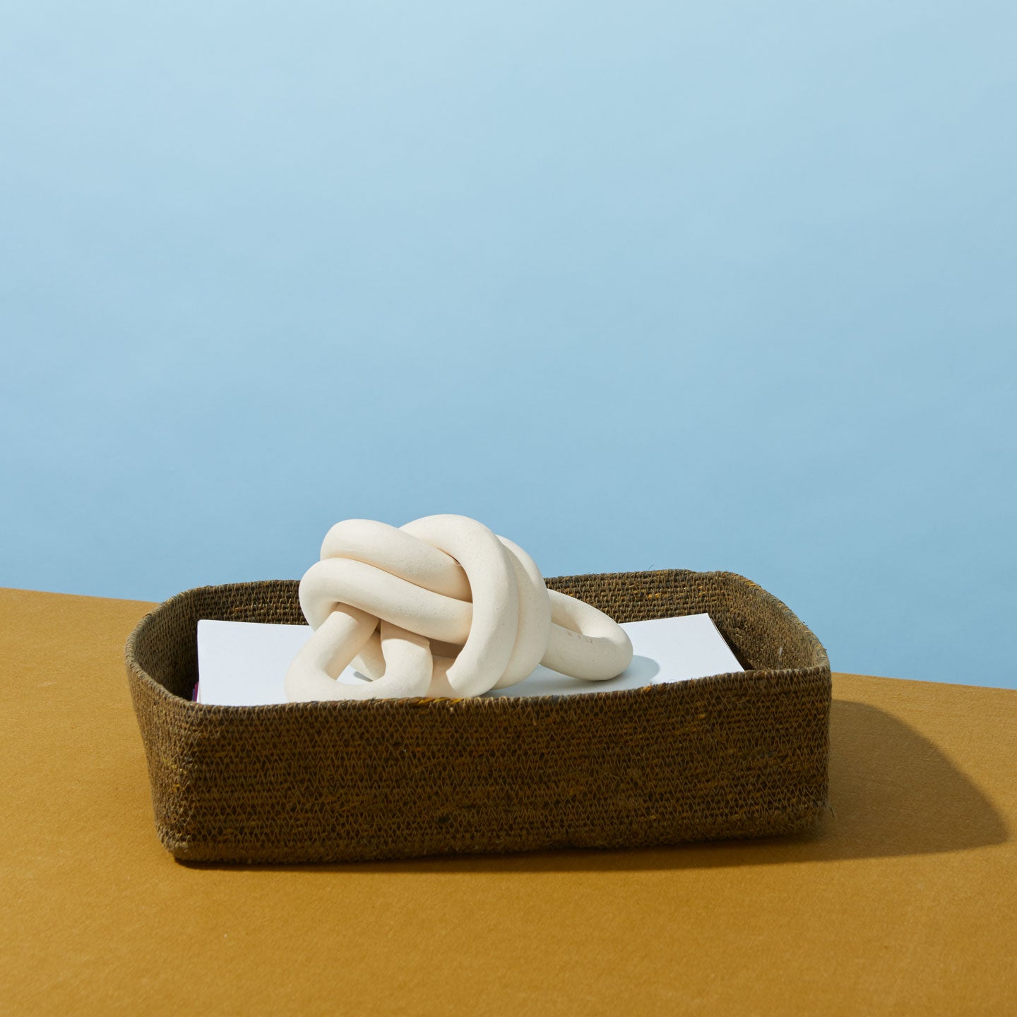 Essential Letter Tray in Olive filled with notepads and a paper weight.