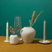 Grouping of vases, candle holders and candles with flowers.