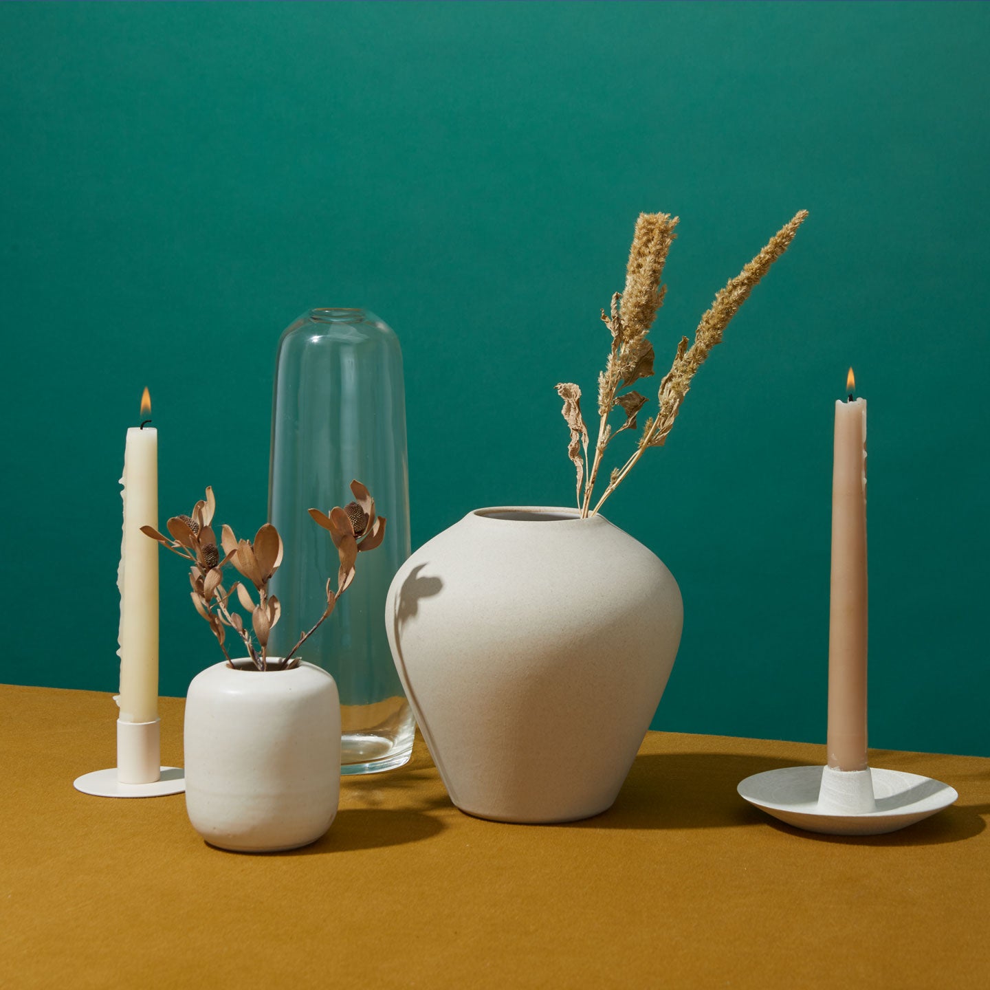 Group of vases and taper candles in holders.