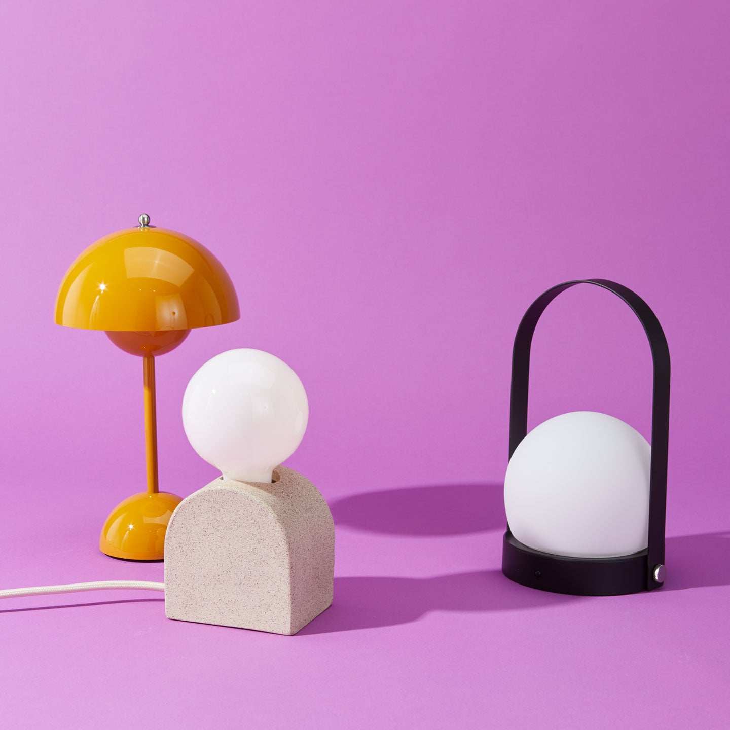 Carrie LED lamp in black, mustard flowerpot lamp and Sin lamp on purple background