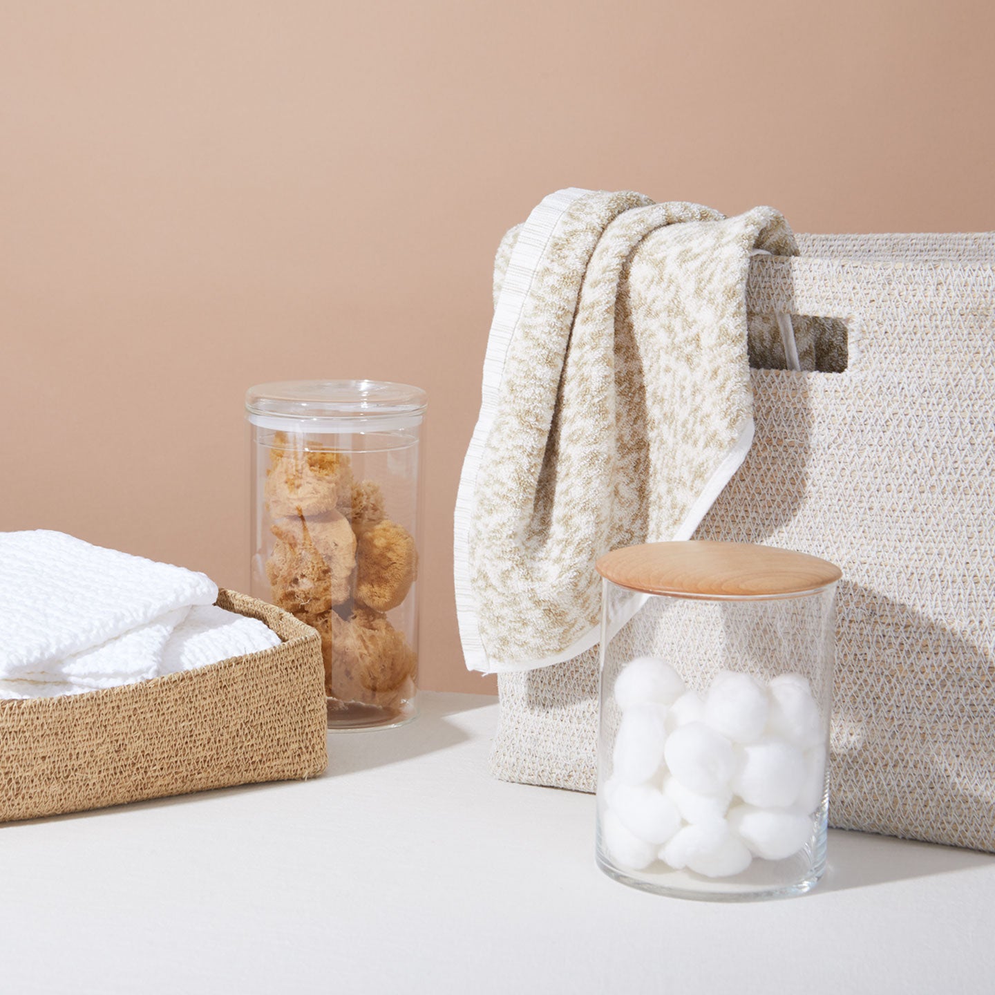 Group of baskets, glass storage canisters and towels.