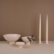 A trio of footed bowls and pair of candle holders, all in Ivory, with ivory taper candles. Styled with a butterfly.