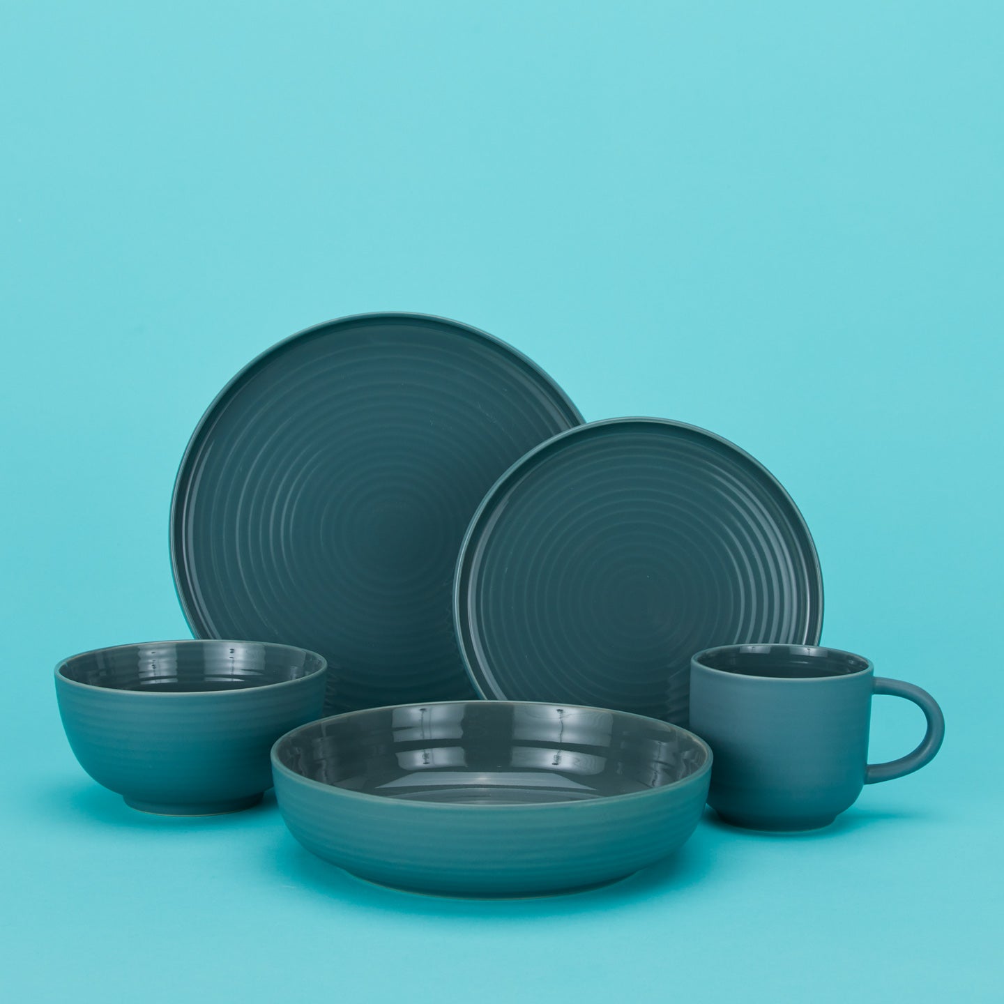 Essential dinnerware set in peacock with plates bowls and mug 