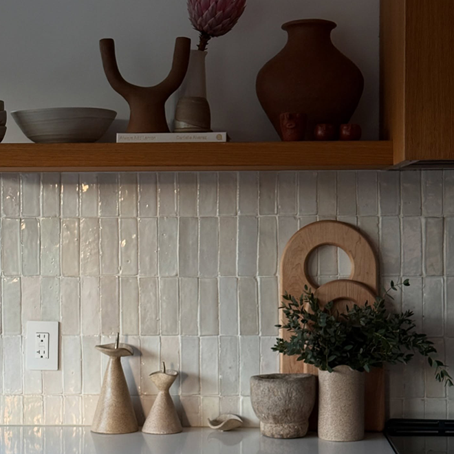 Decorative kitchen scene with ceramic vases and a tiled wall.