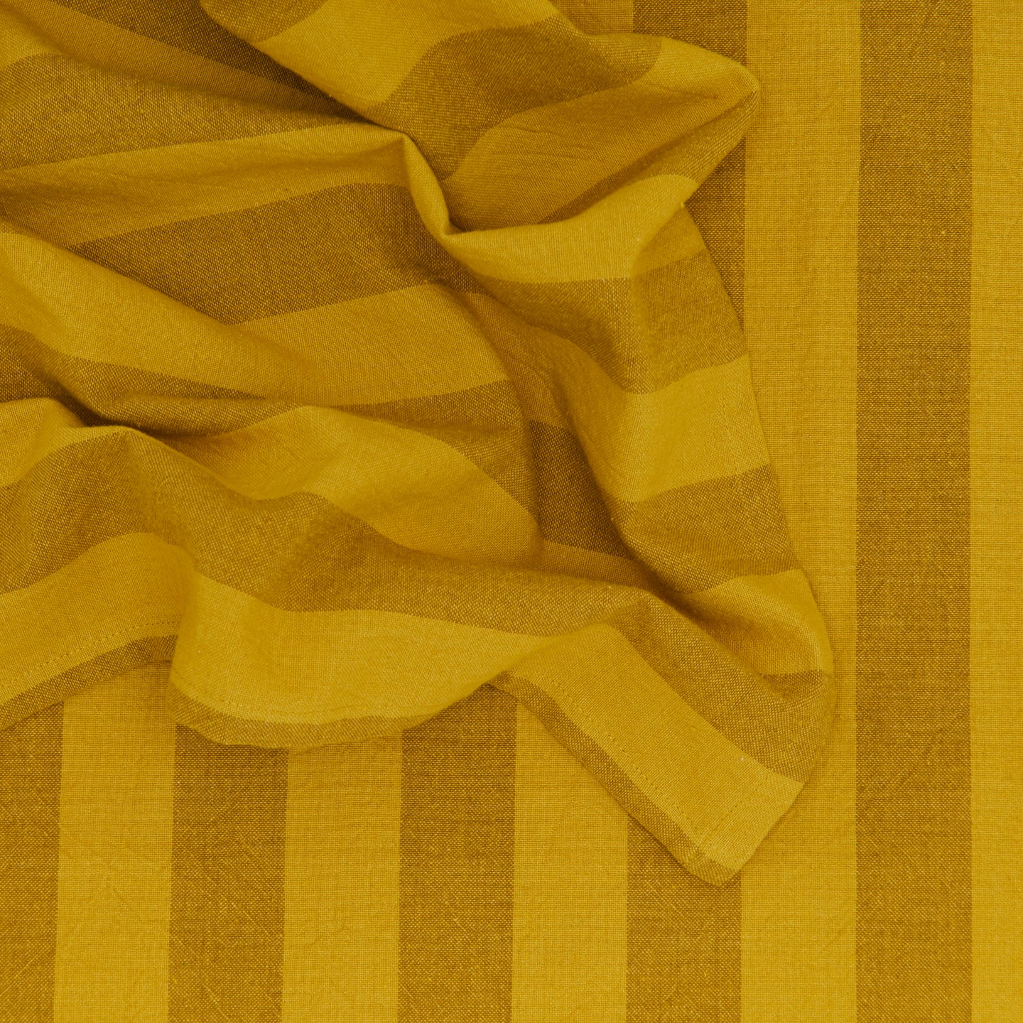 Close up of Essential Striped Dinner Napkin in Mustard and Bronze.