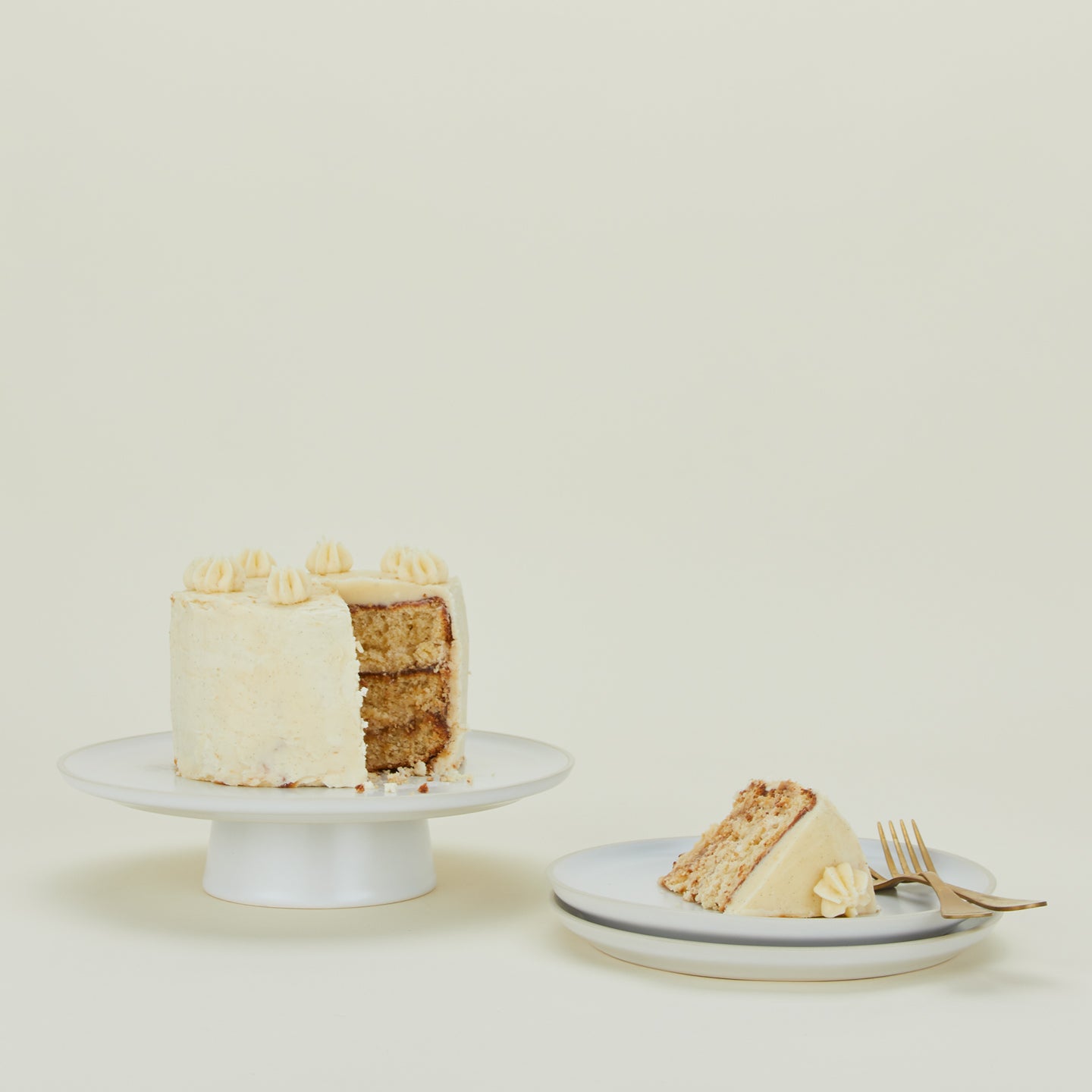 Modernist Cake Plate with layer cake, stack of plates and group of forks.
