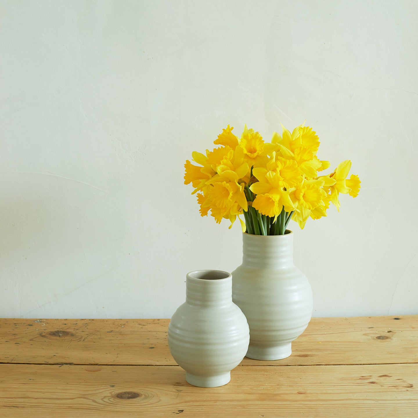 Essential Ceramic Vase in Light Grey on wood countertop with daffodils.