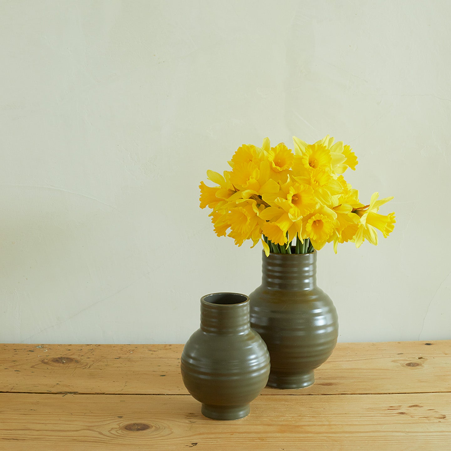 Essential Ceramic Vase in Olive on wood countertop with daffodils.