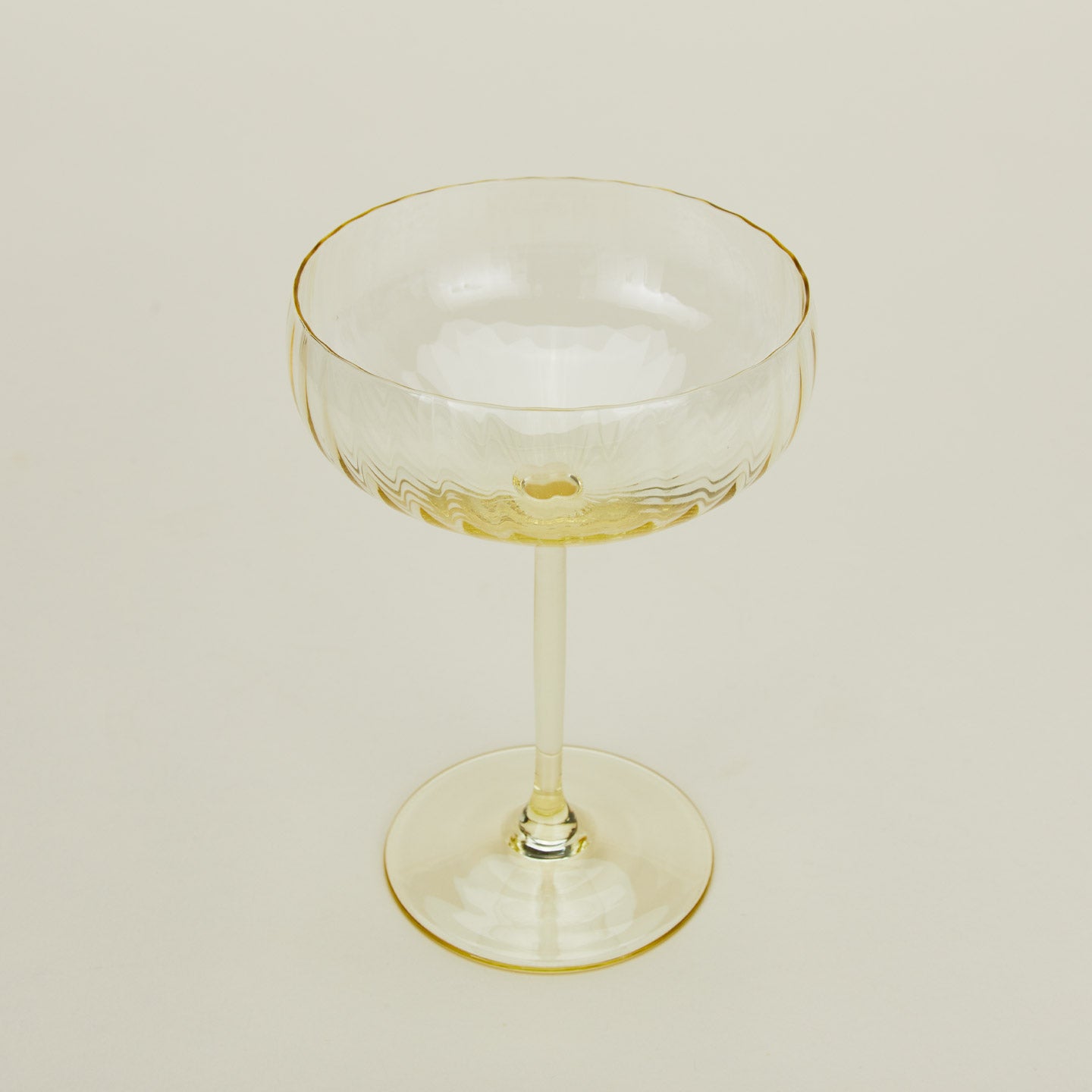 Close up of ribbed amber cocktail coupe glass.