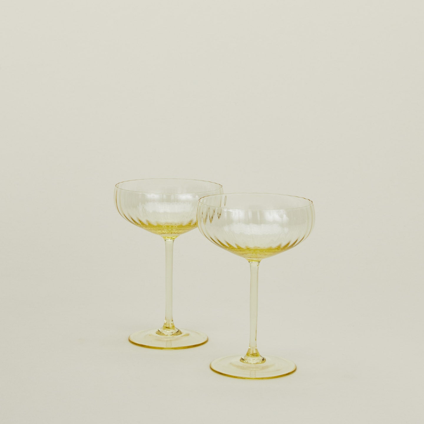 Set of two ribbed amber cocktail coupe glasses.