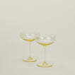 Set of two ribbed amber cocktail coupe glasses.