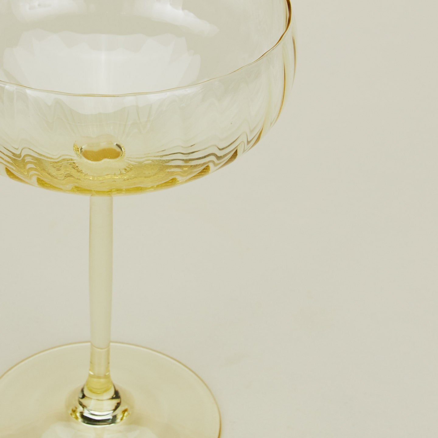 Close up of ribbed amber cocktail coupe glass.