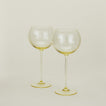 Set of two ribbed amber wine glasses.
