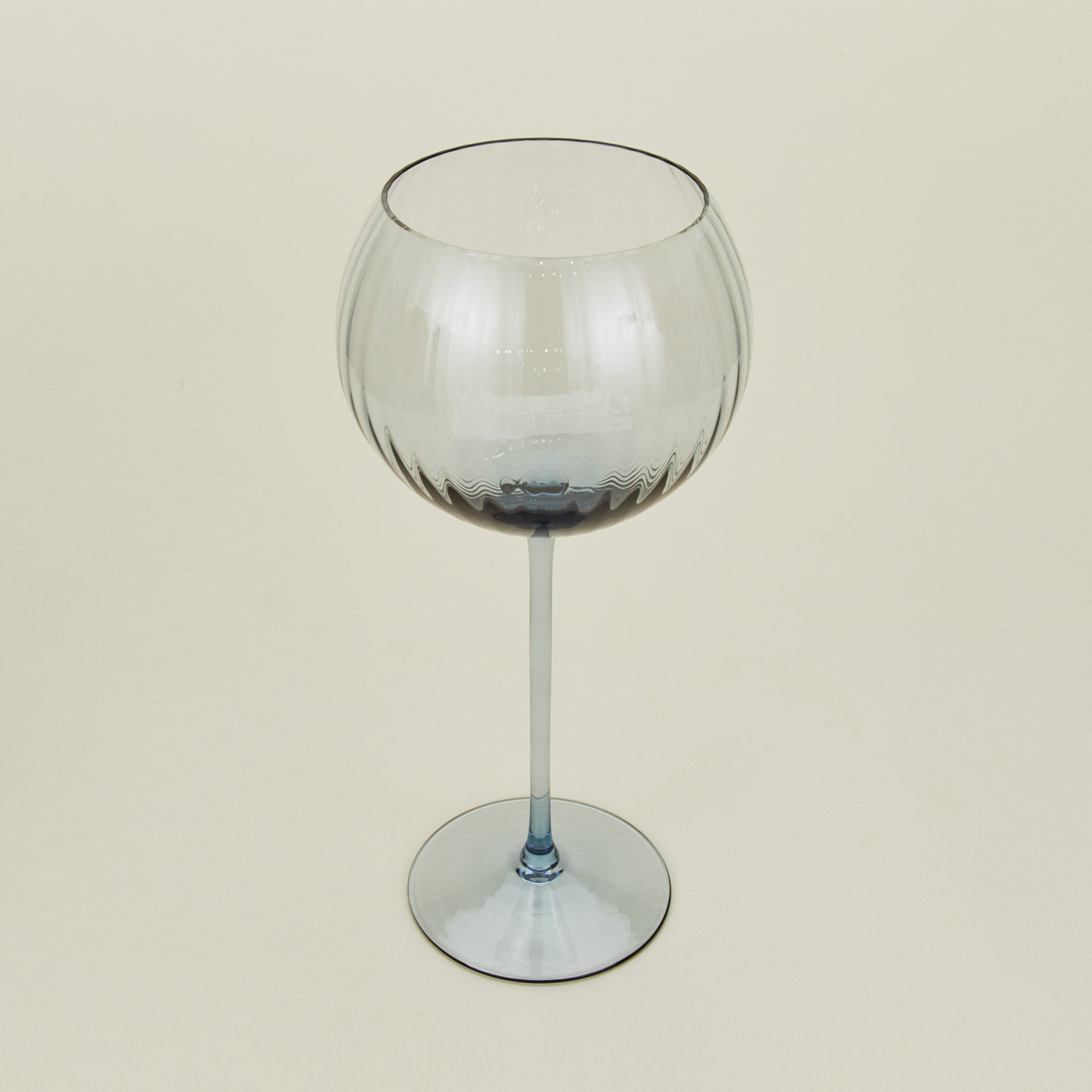 Three-quarter angle of ribbed blue wine glass.