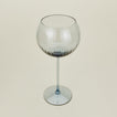Three-quarter angle of ribbed blue wine glass.