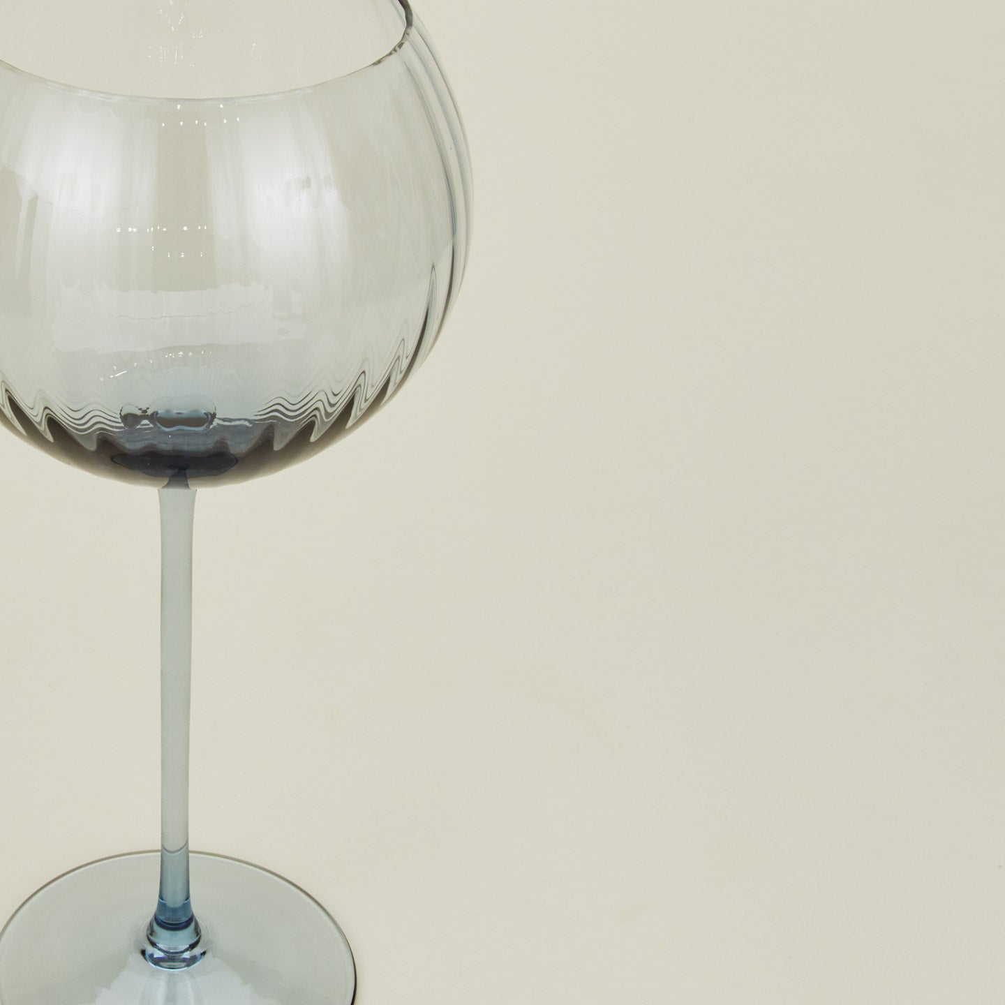 Close up of ribbed blue wine glass.