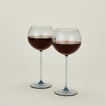Set of two ribbed  blue wine glasses with red wine.
