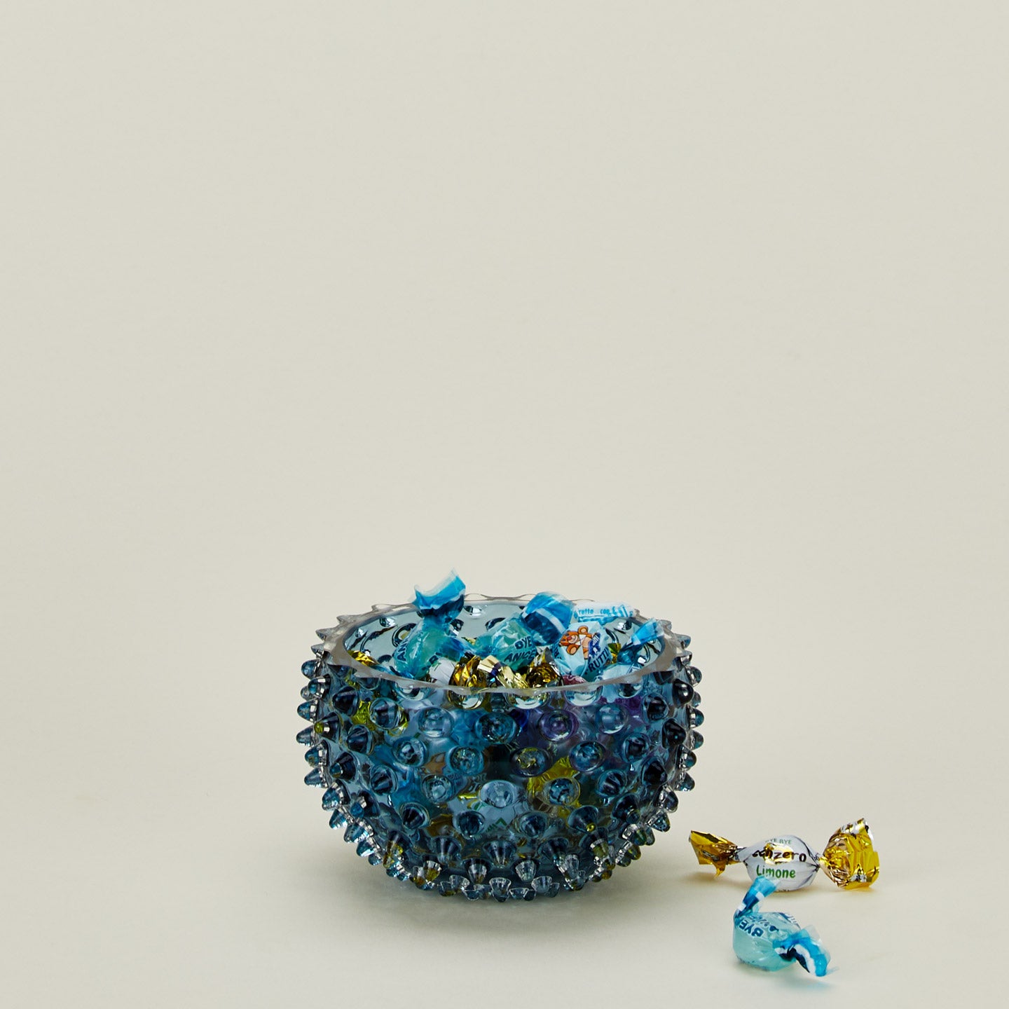 Glass hobnail blue tapas bowl with candy.