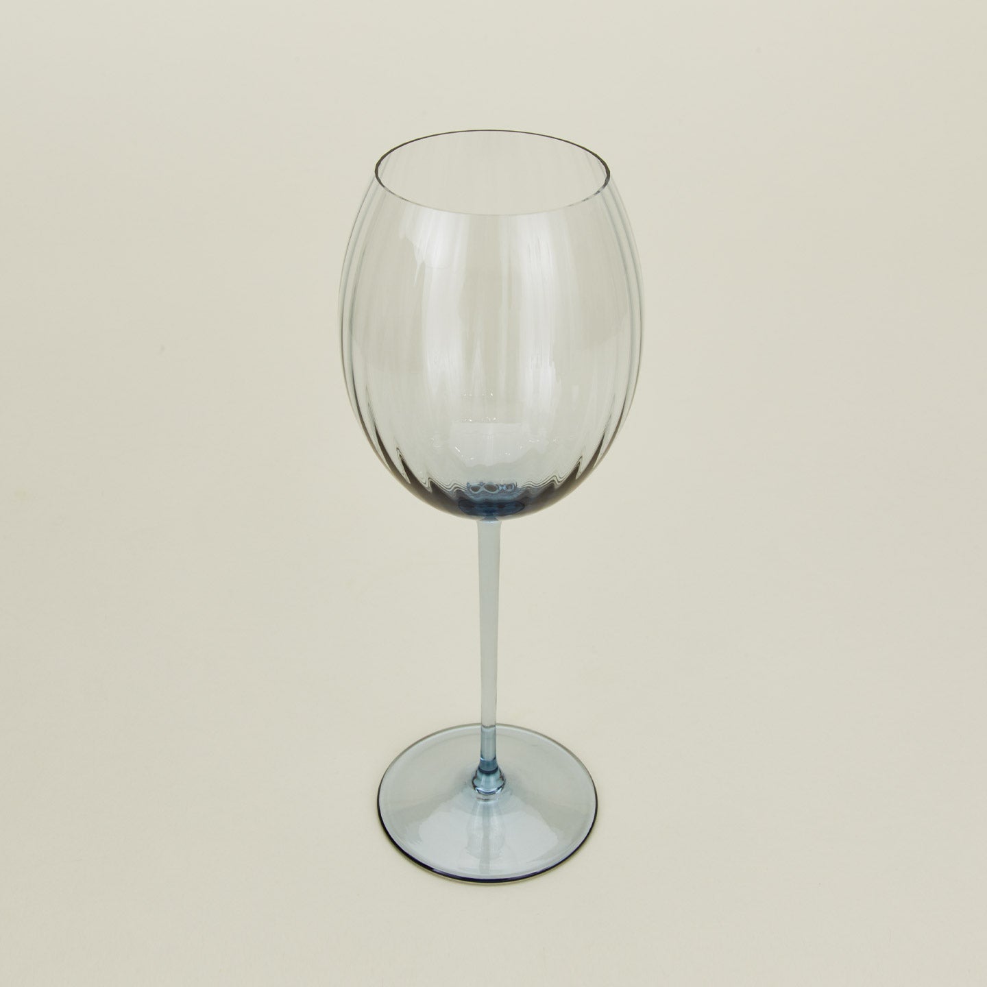 Three-quarter angle of ribbed blue wine glass.