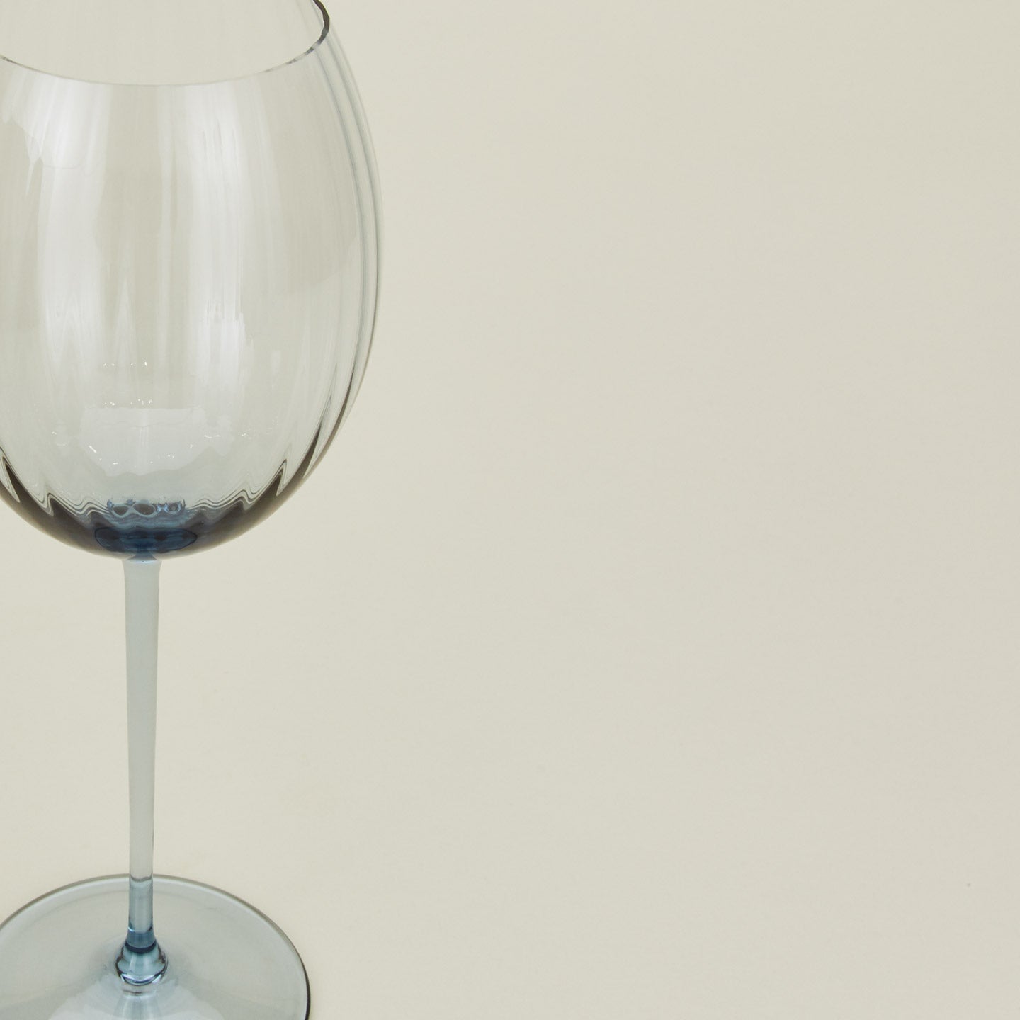 Close up of ribbed blue wine glass.