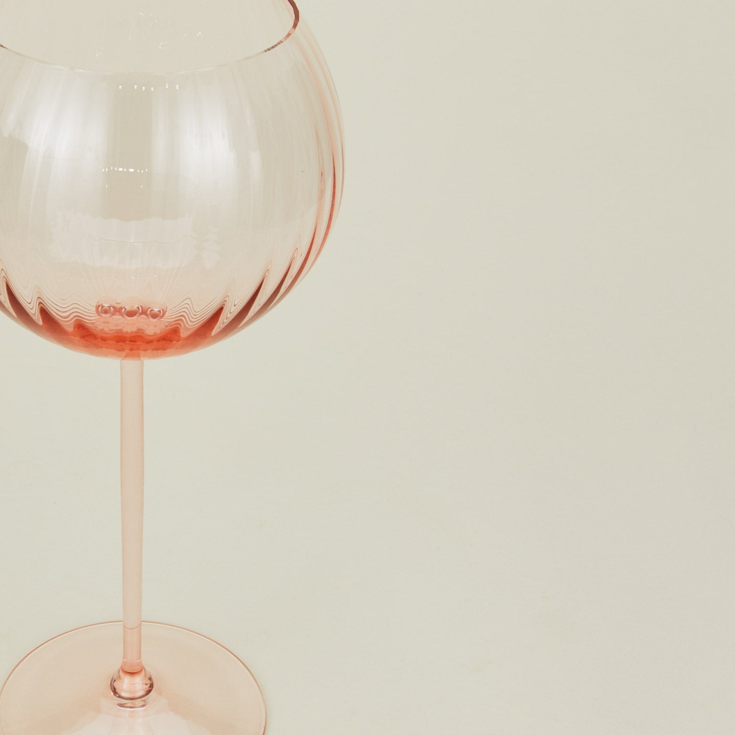 Close up of ribbed blush wine glass.