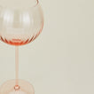 Close up of ribbed blush wine glass.
