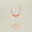 Three-quarter angle of ribbed blush wine glass.
