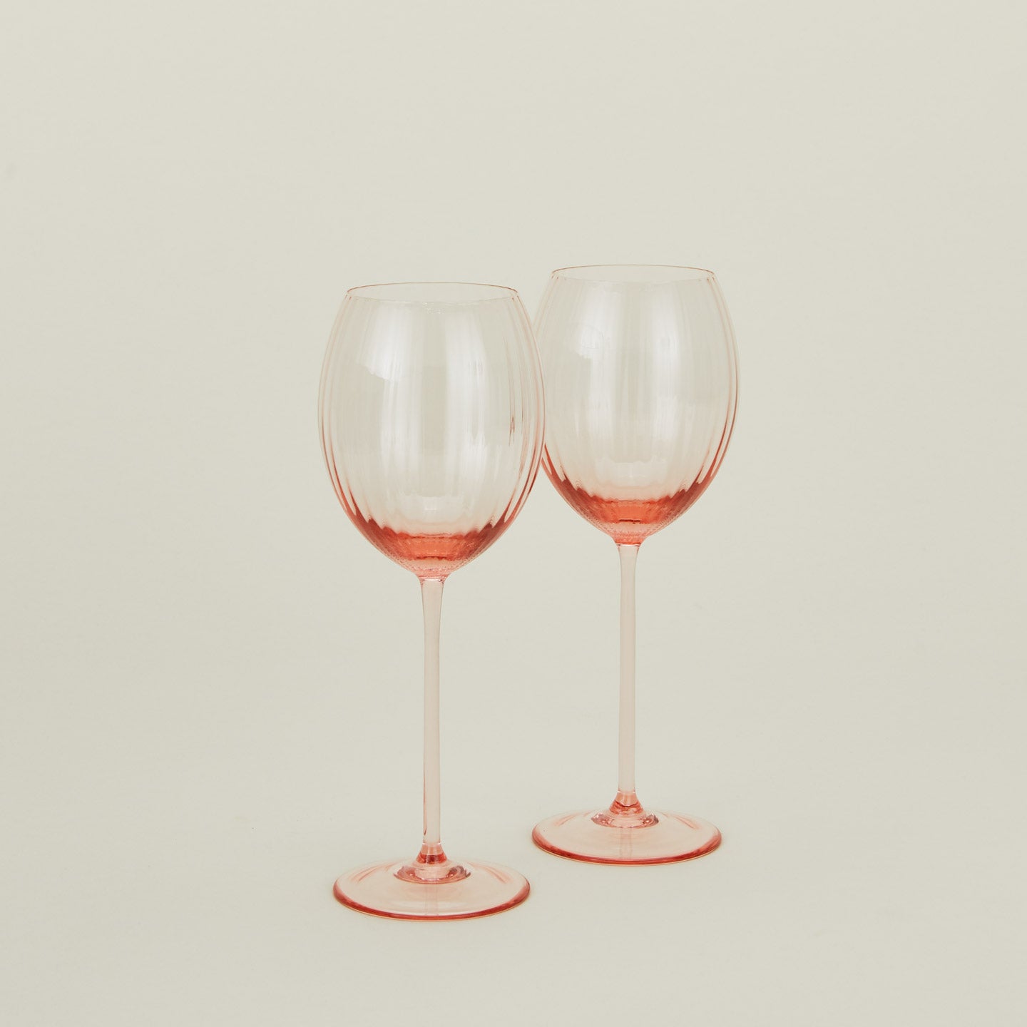 Set of two ribbed blush wine glasses.
