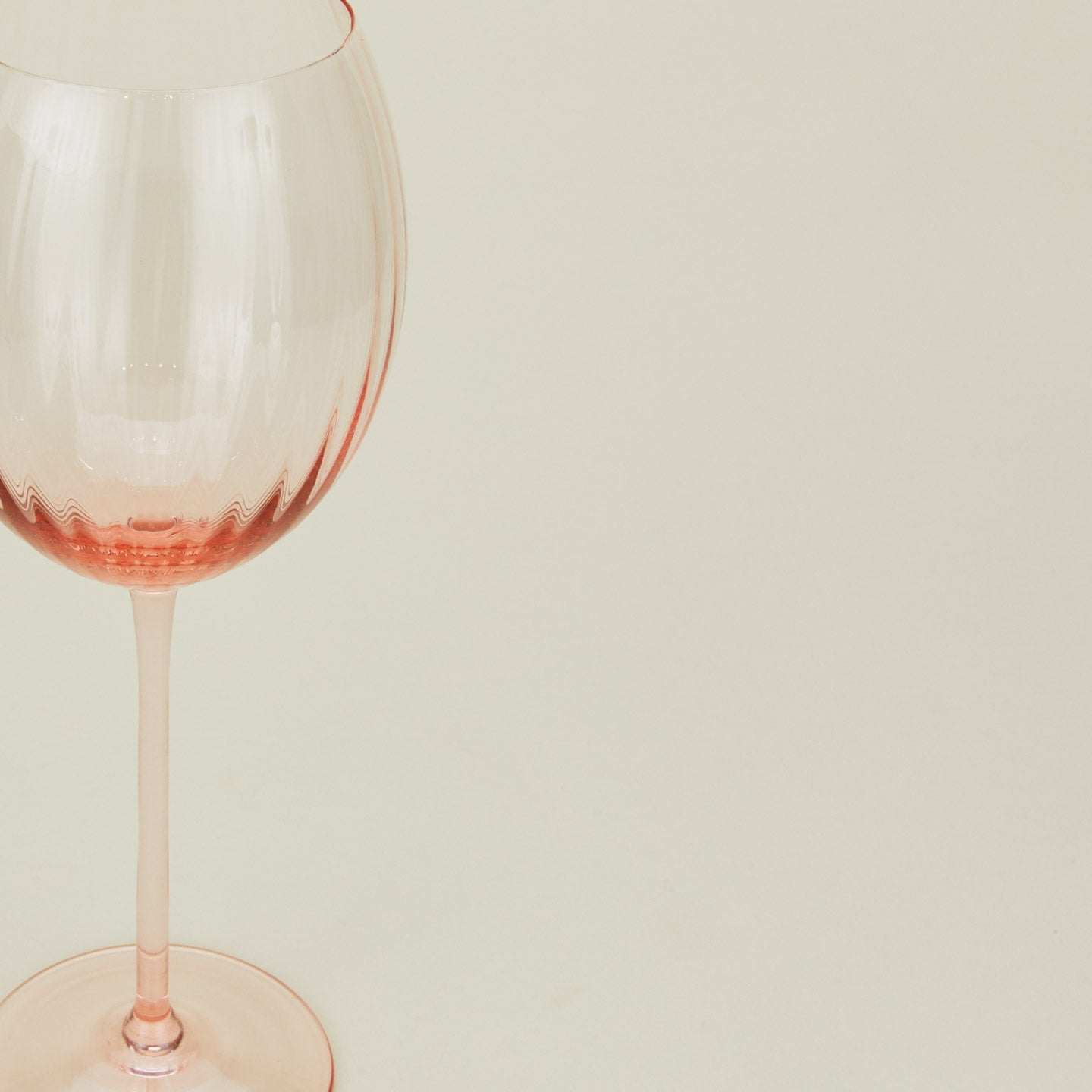 Close up of ribbed blush wine glass.