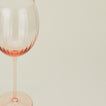 Close up of ribbed blush wine glass.