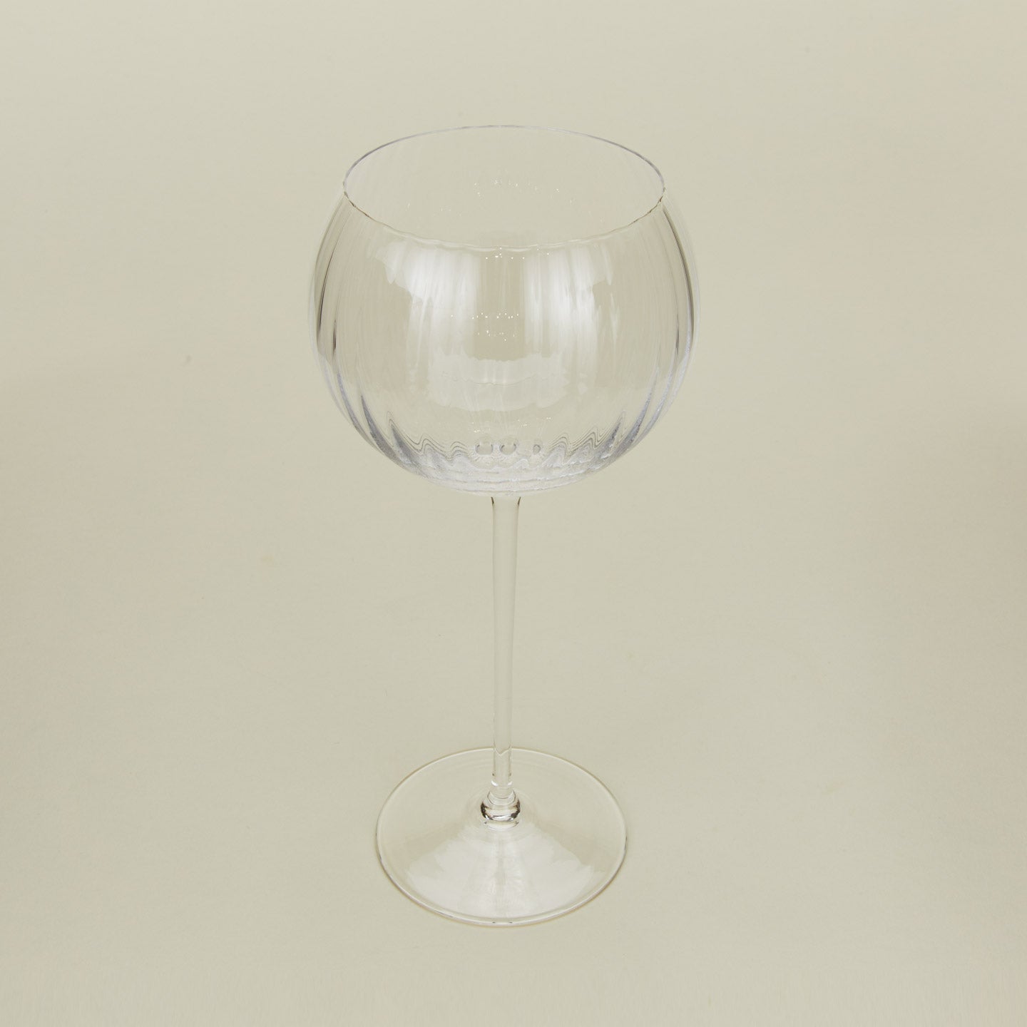 Three-quarter angle of ribbed clear wine glass.