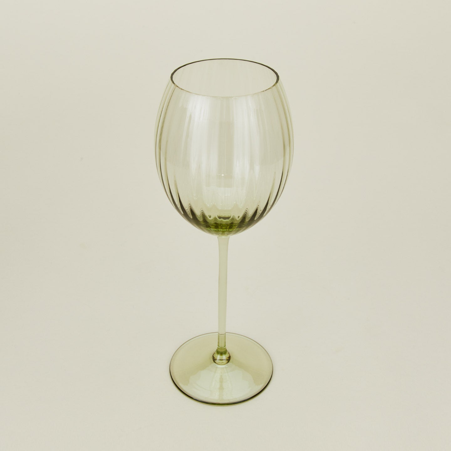 Three-quarter angle of ribbed olive wine glass.