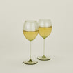 Set of two ribbed olive wine glasses with white wine.
