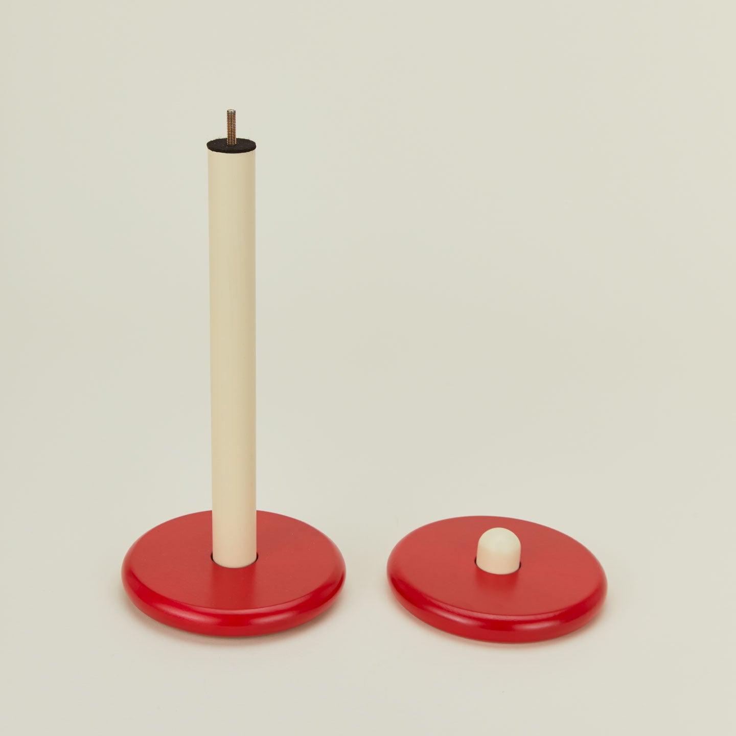 A red and yellow paper towel holder disassembled.