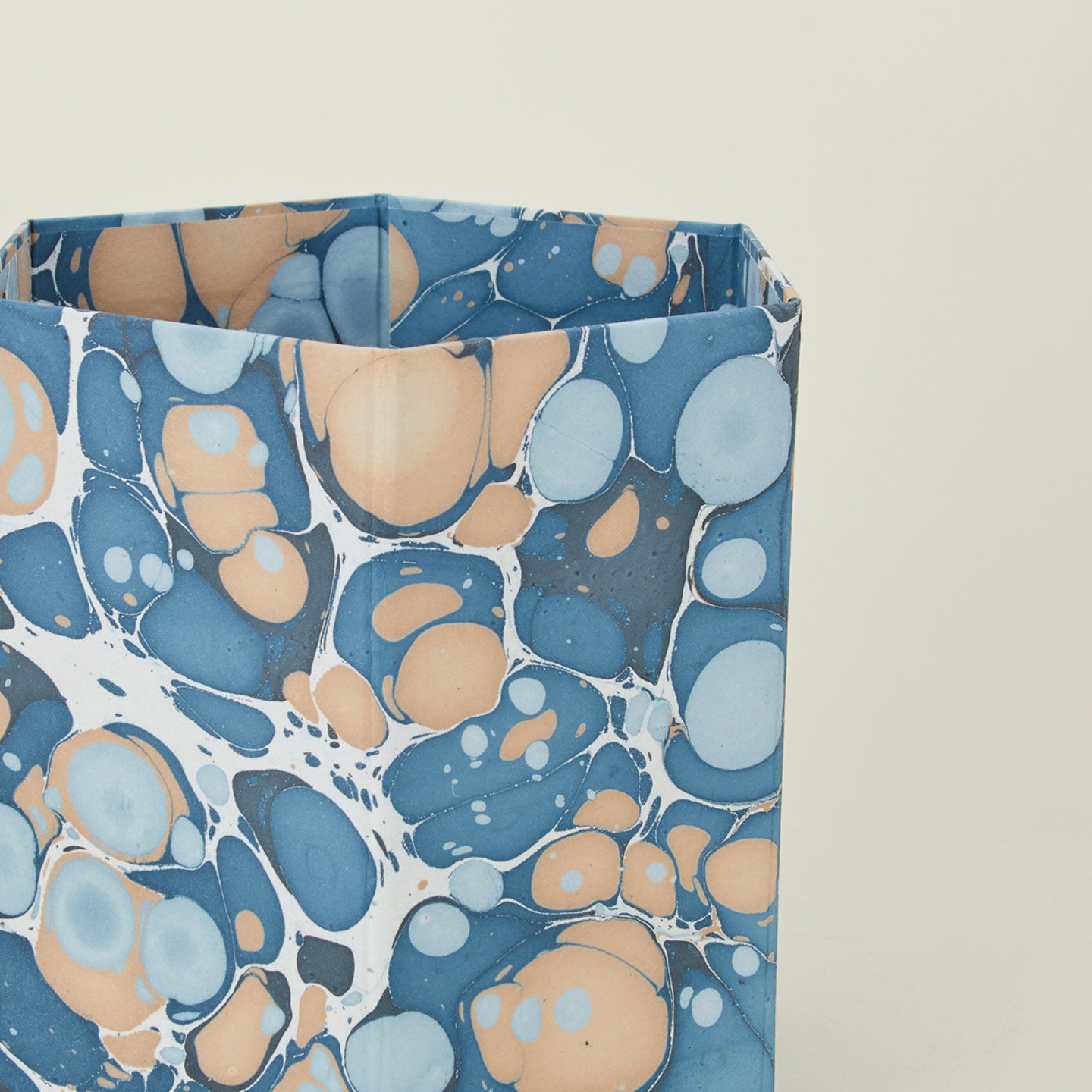 Detail of marbled hexagon wastebasket in cool tones.