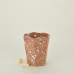 Marbled scalloped wastebasket in mocha with balled-up paper.