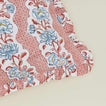 Detail of block printed floral ruffled pillow in blush.