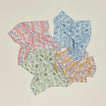 Unfolded floral block printed napkins in various colors.