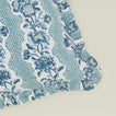 Detail of block printed floral ruffled pillow in indigo.