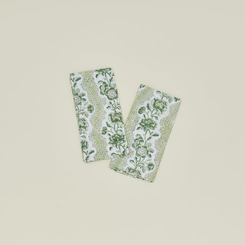 A set of two block printed napkins with a floral pattern in olive.