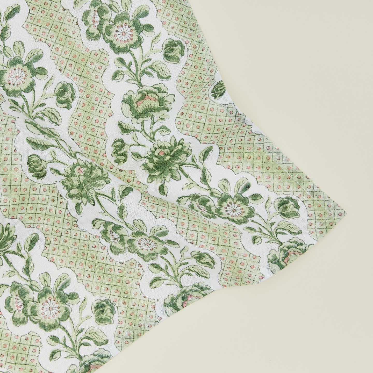 Detail of block printed napkin with a floral pattern in olive.