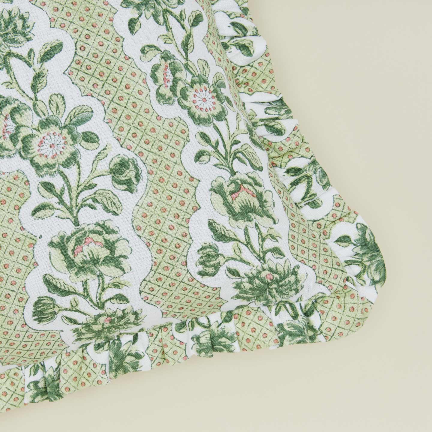 Detail of block printed floral ruffled pillow in olive.