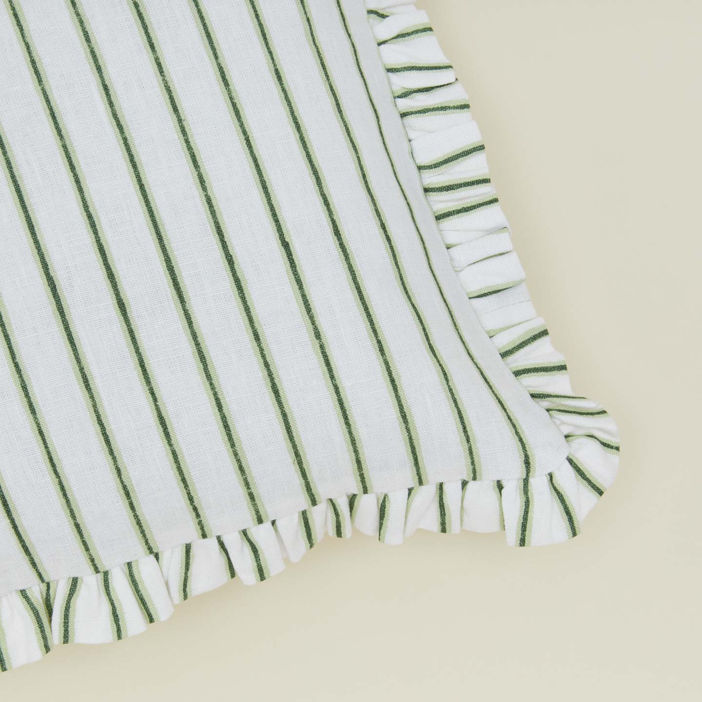Detail of block printed striped ruffled pillow in olive.