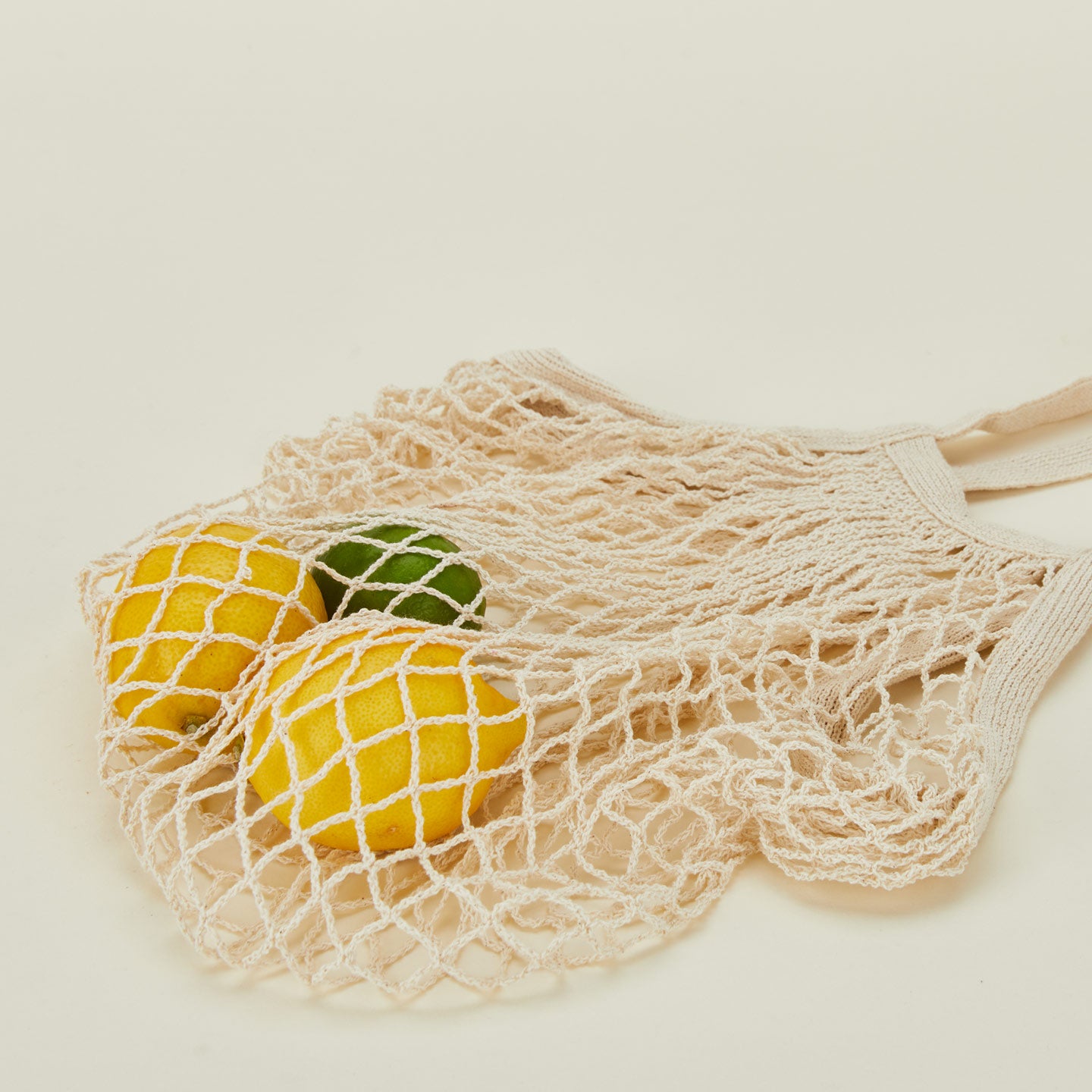 Close up view of Ecofreax reusable mesh cotton grocery bag with lemons