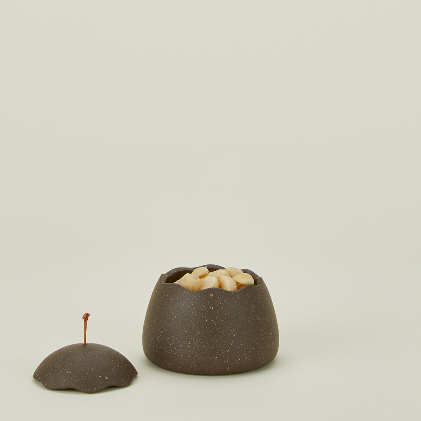 Stoneware squiggle jar with lid removed and filled with macadamia nuts