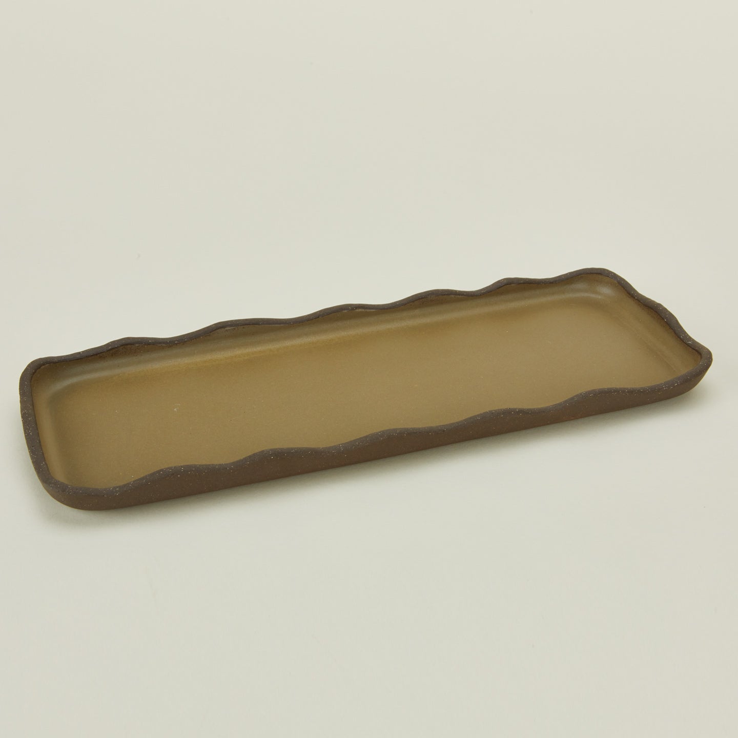 Detailed view of stoneware wavy tray in olive
