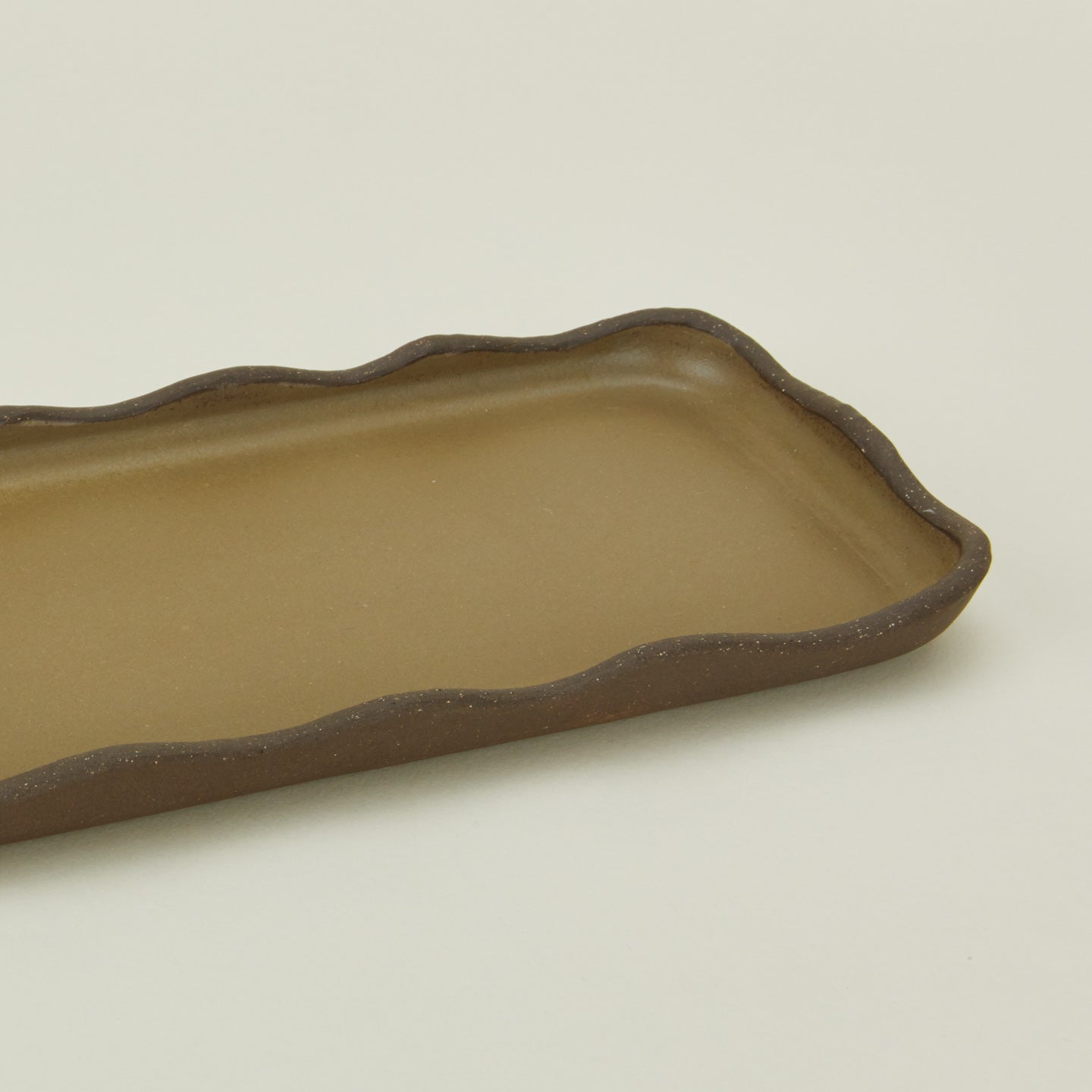 Close up view of stoneware wavy tray in olive