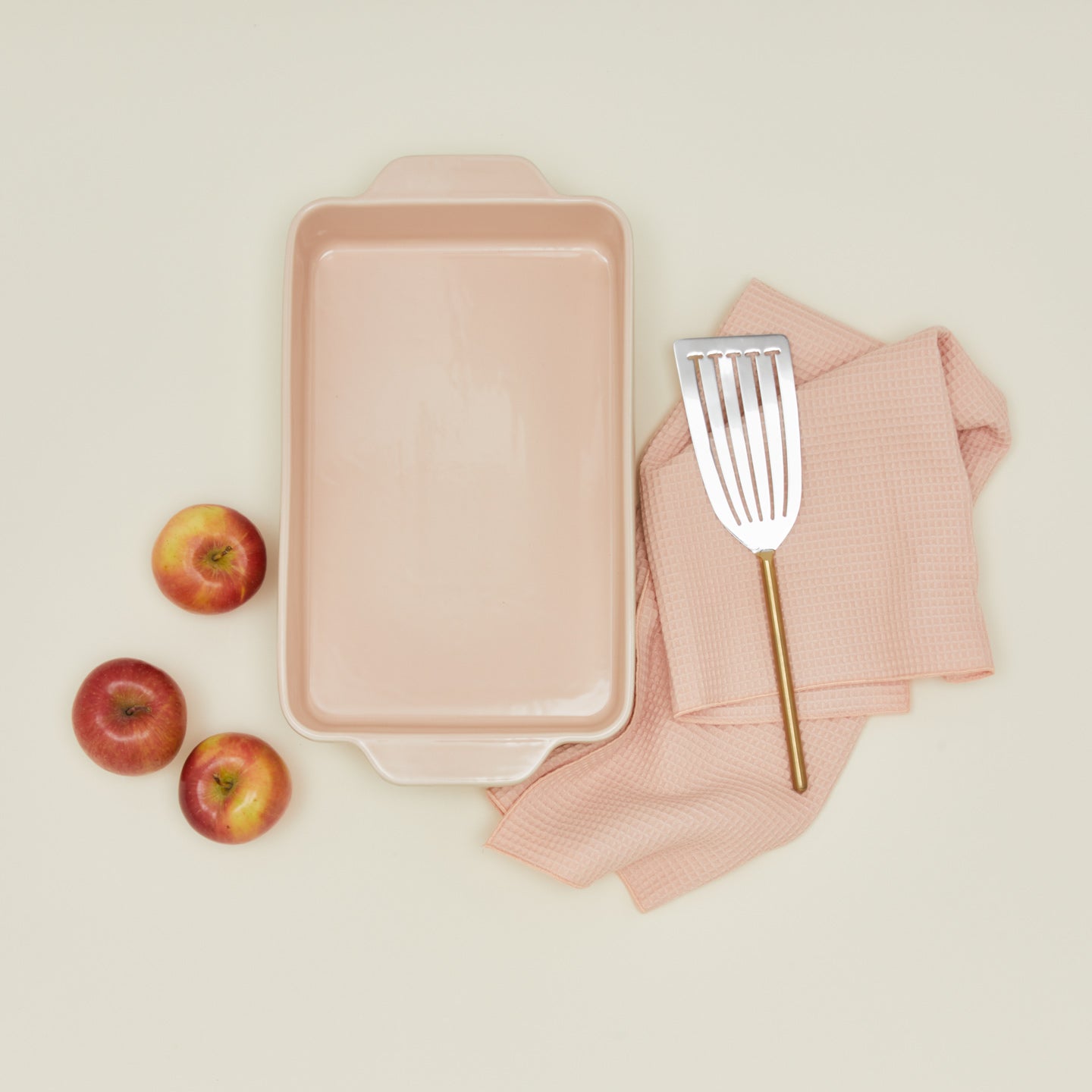 9" x 13" in essential bakeware in blush with apples, spatula, and dish towel