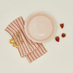 pie dish in blush with strawberries dish towel and measuring spoons