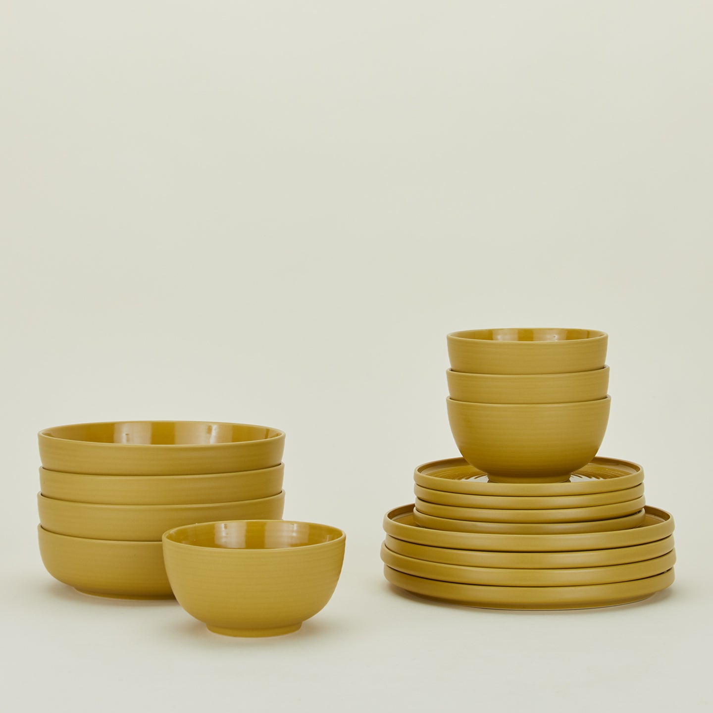 Set of mustard yellow Essential dinnerware including Large Bowls, Low Bowls, Salad Plates and Dinner Plates.